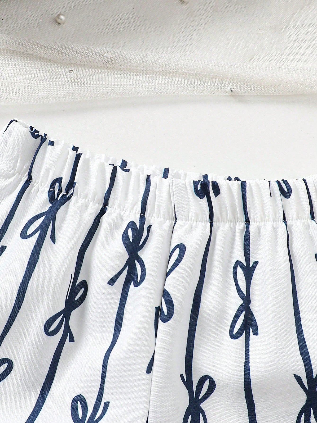 Prenda blanco pantalón para bebe con estampado de lazos detalle de la tela