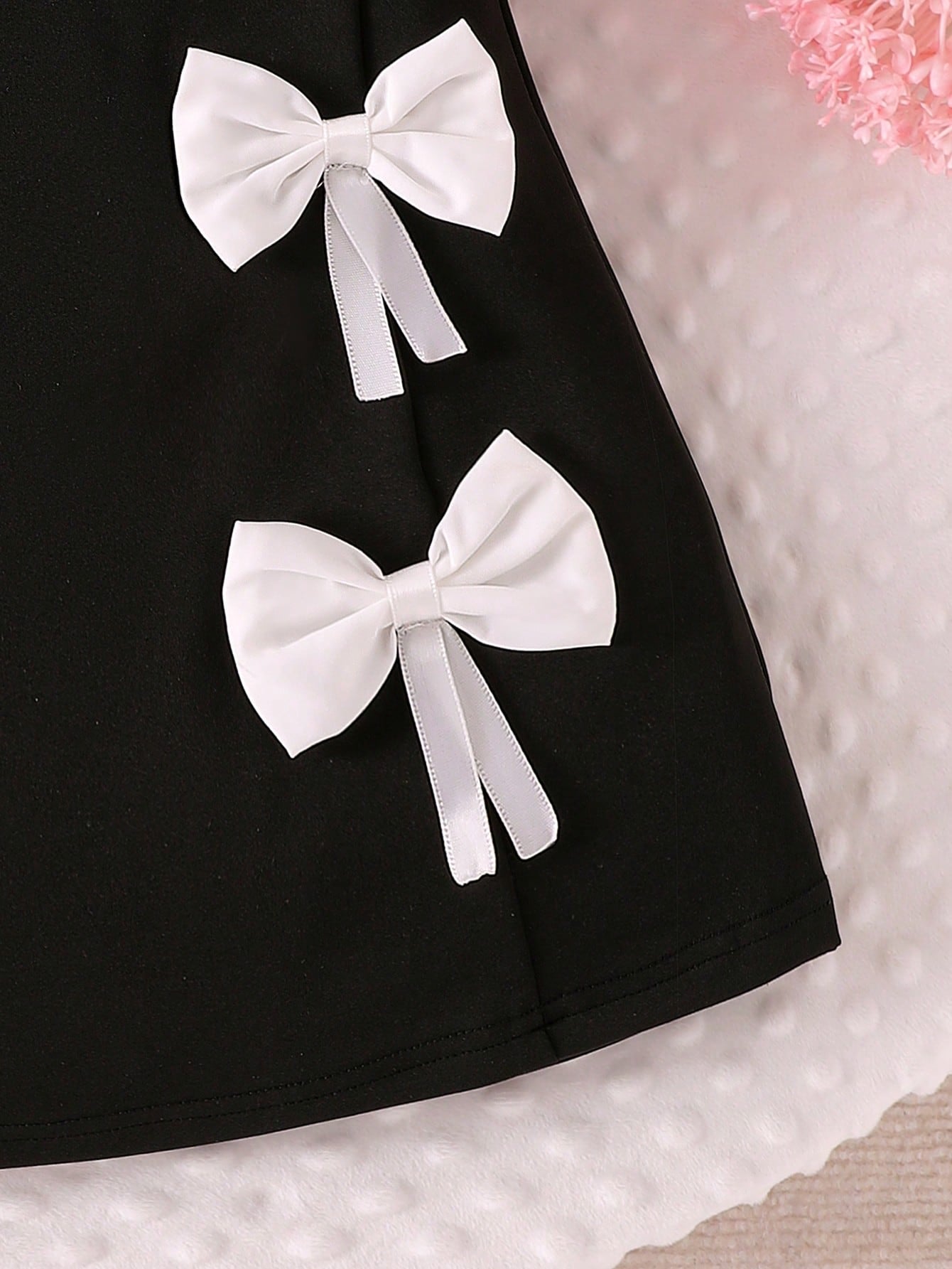 Prenda negro vestido para bebe detalle de lazos decorativos
