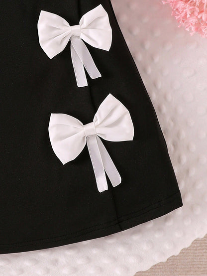 Prenda negro vestido para bebe detalle de lazos decorativos
