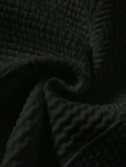 Prenda negra sudadera texturizada para bebe detalle del tejido