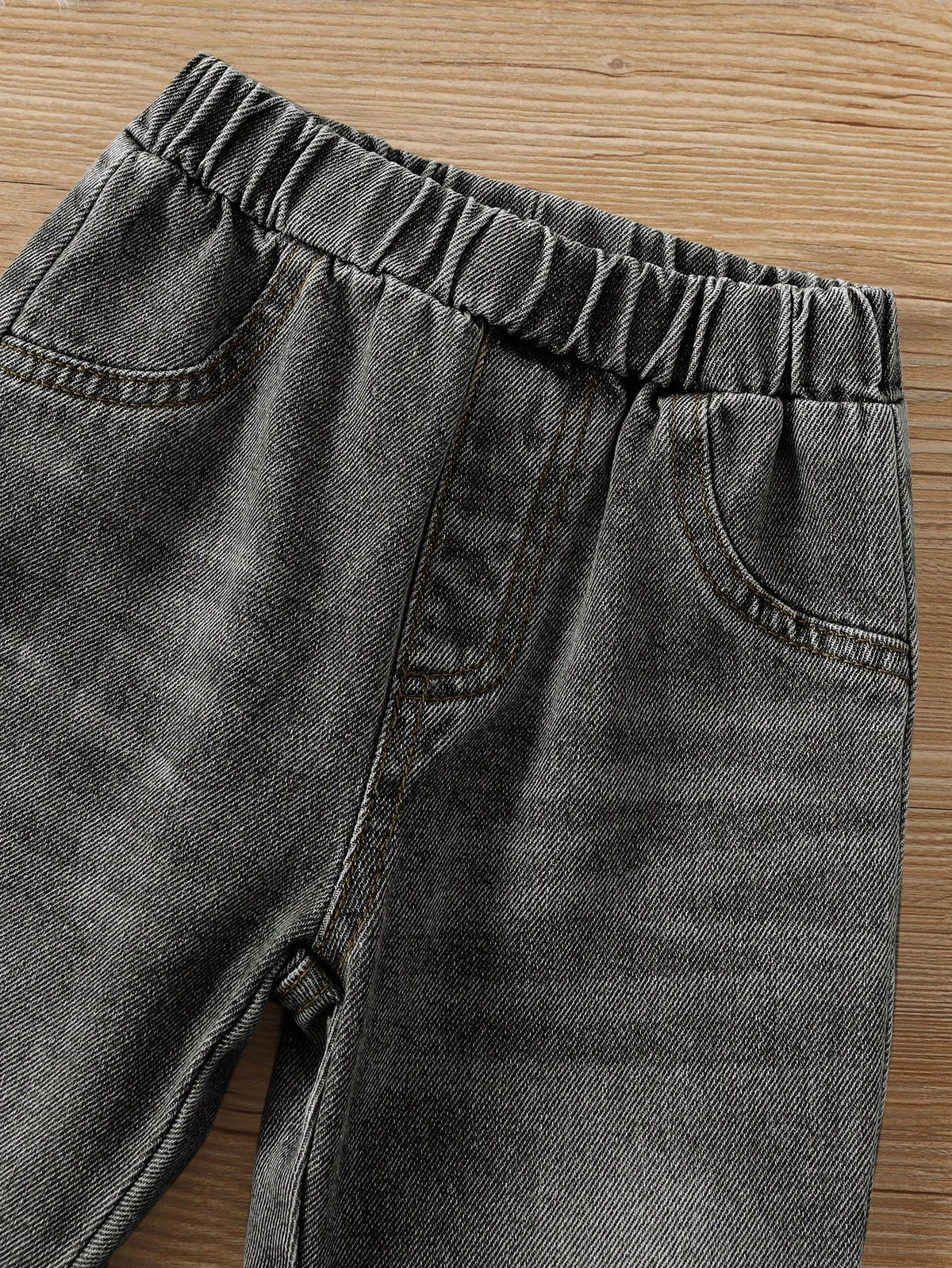 Prenda gris pantalón de mezclilla para bebe detalle de cintura elástica