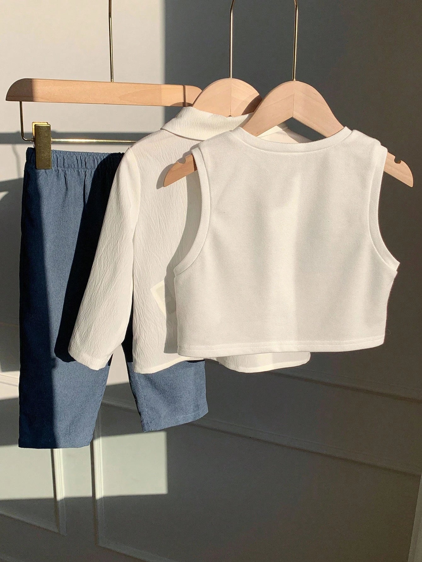 Prenda blanca y azul conjunto de tres piezas para bebe vista posterior