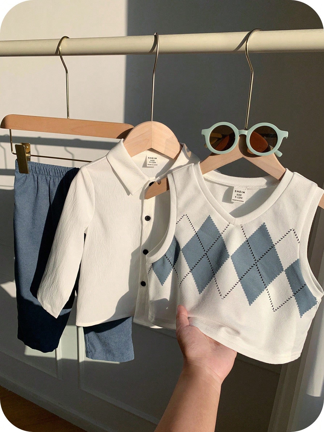 Prenda blanca y azul conjunto de tres piezas para bebe con chaleco argyle vista frontal
