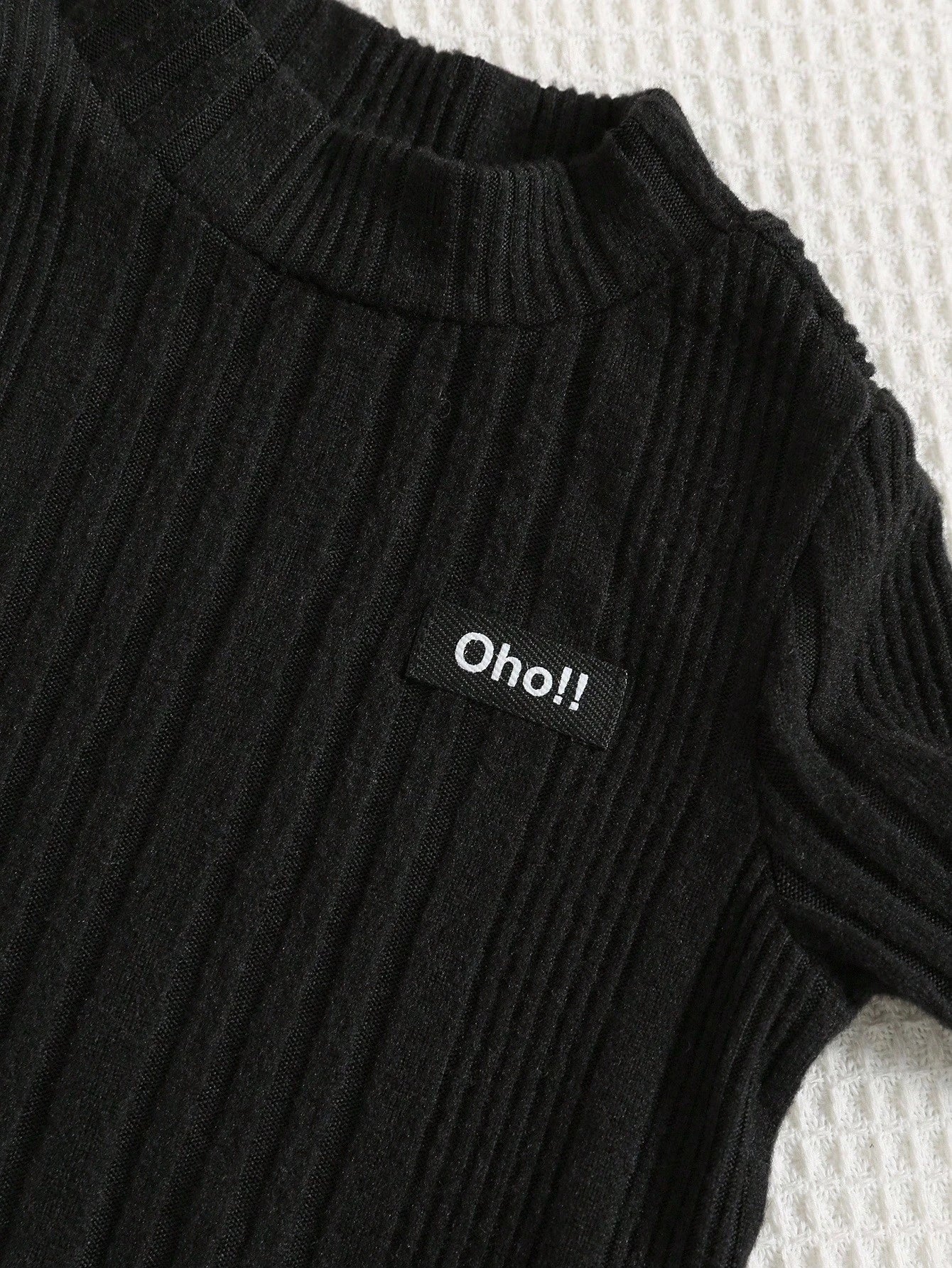 Prenda negra top para bebe detalle acanalado con parche frontal
