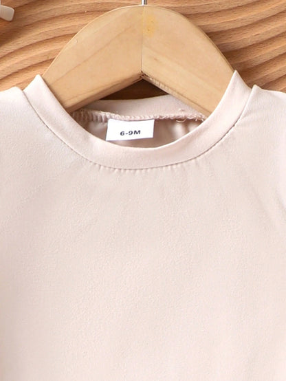 Prenda beige blusa para bebe detalle de cuello redondo y manga larga