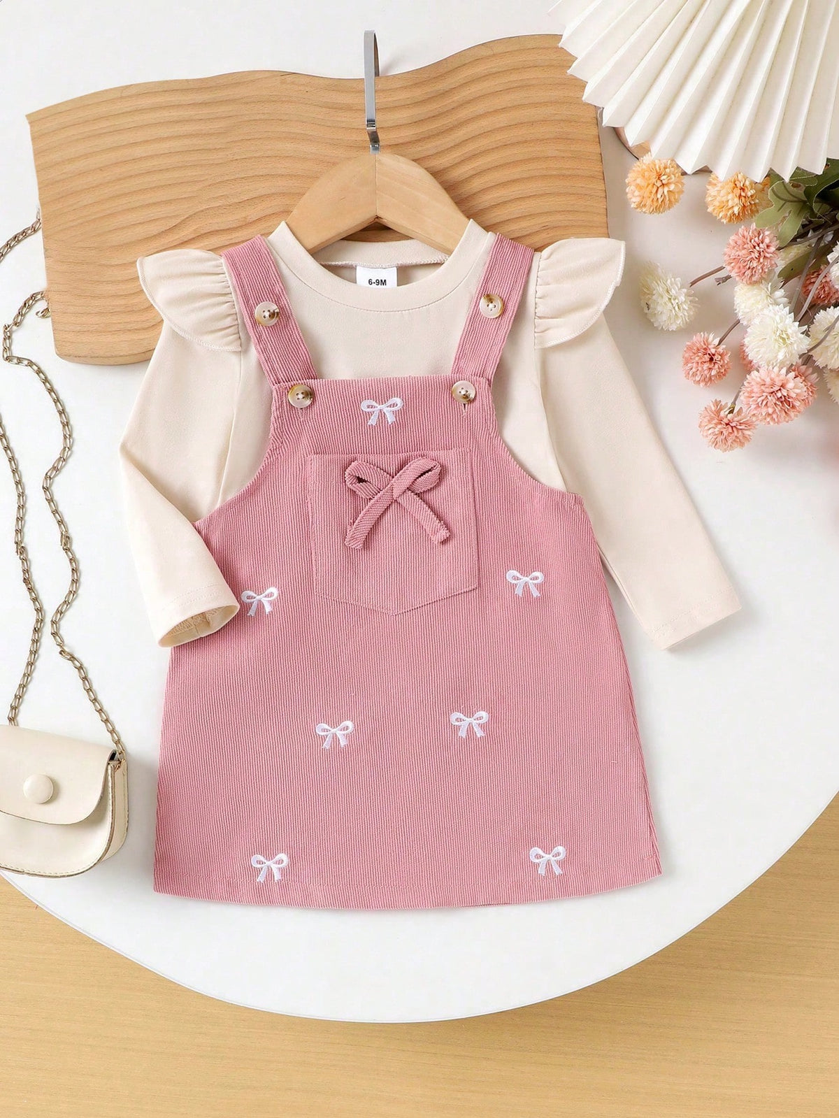 Prenda rosa conjunto para bebe con vestido de tirantes y lazos bordados vista frontal
