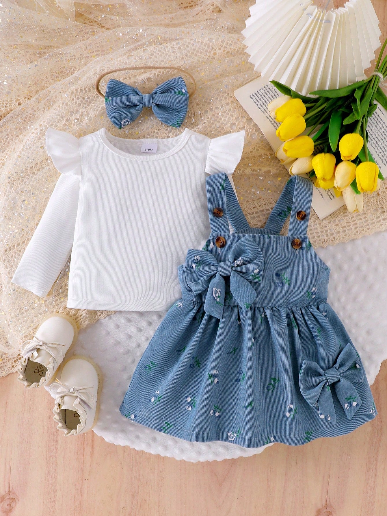 Prenda azul conjunto para bebe con vestido floral y moño vista frontal

