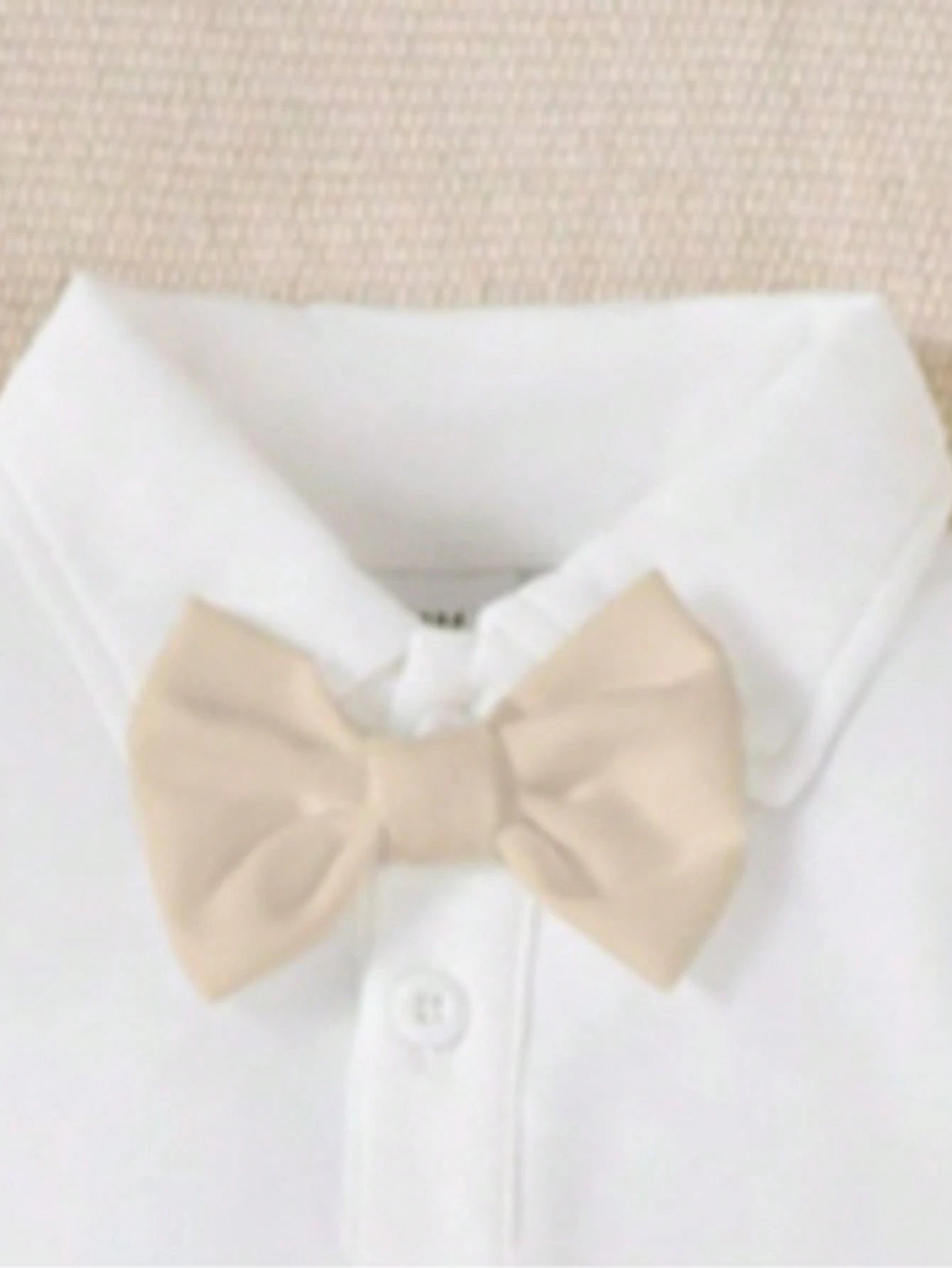 Prenda blanca pelele para bebe con detalle de moño caqui
