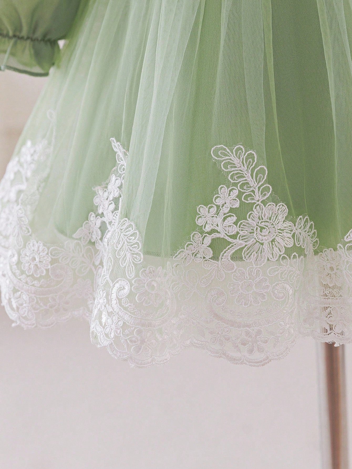 Prenda verde vestido para bebe con detalle de encaje floral blanco