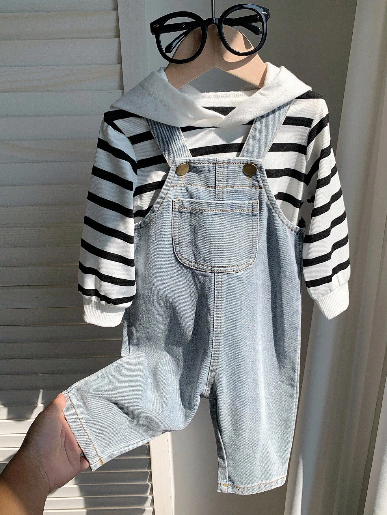 Prenda blanca conjunto para bebe con sudadera a rayas y overol azul detalle frontal