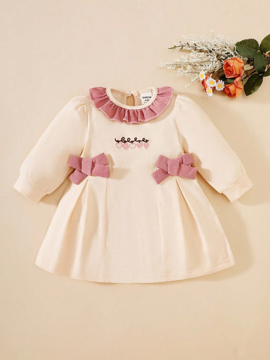 Prenda albaricoque vestido para bebe vista frontal con volantes rosados
