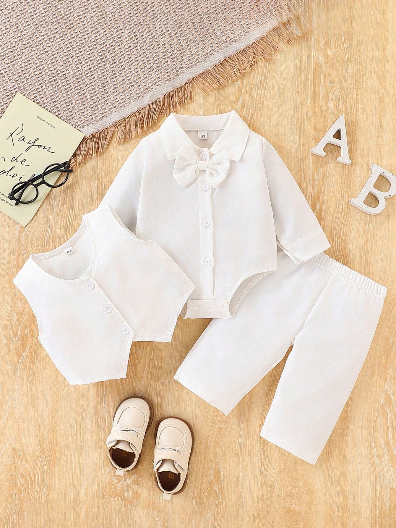 Prenda blanca conjunto para bebe con body, chaleco y pantalón vista frontal