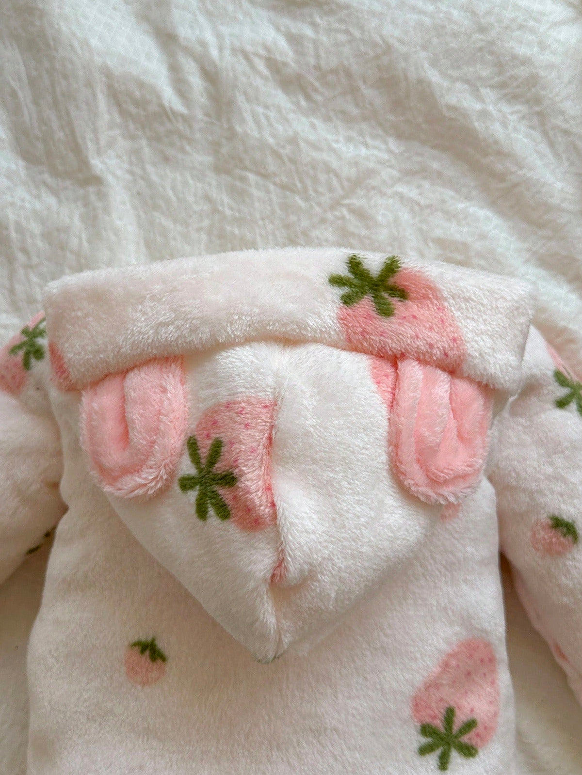 Mameluco rosa de felpa para bebe con detalle de orejitas decorativas
