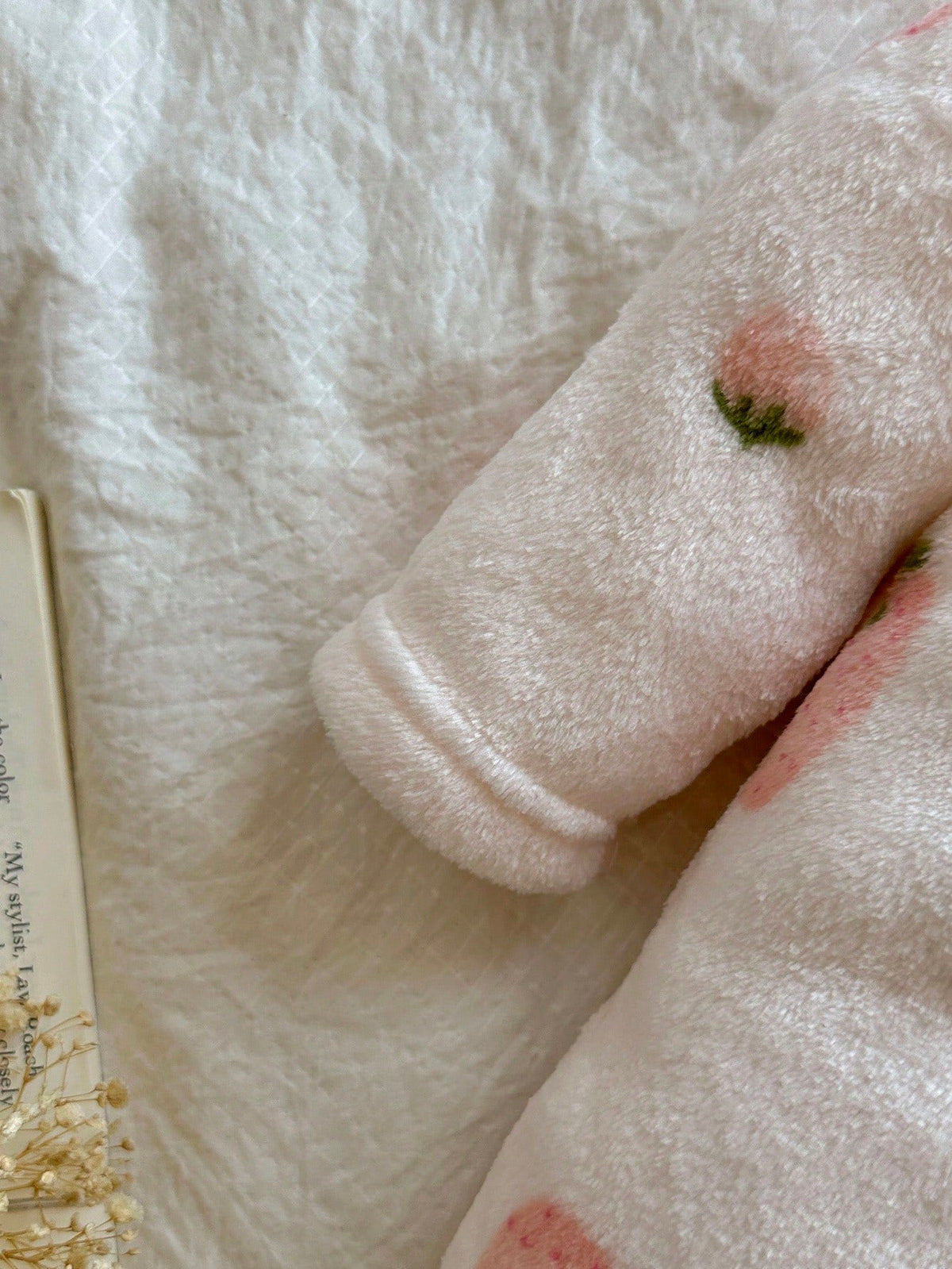 Mameluco rosa para bebe con detalle de manga larga y textura afelpada