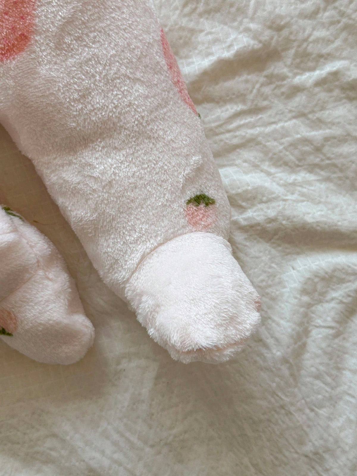 Mameluco rosa de felpa para bebe con detalle de pies cubiertos