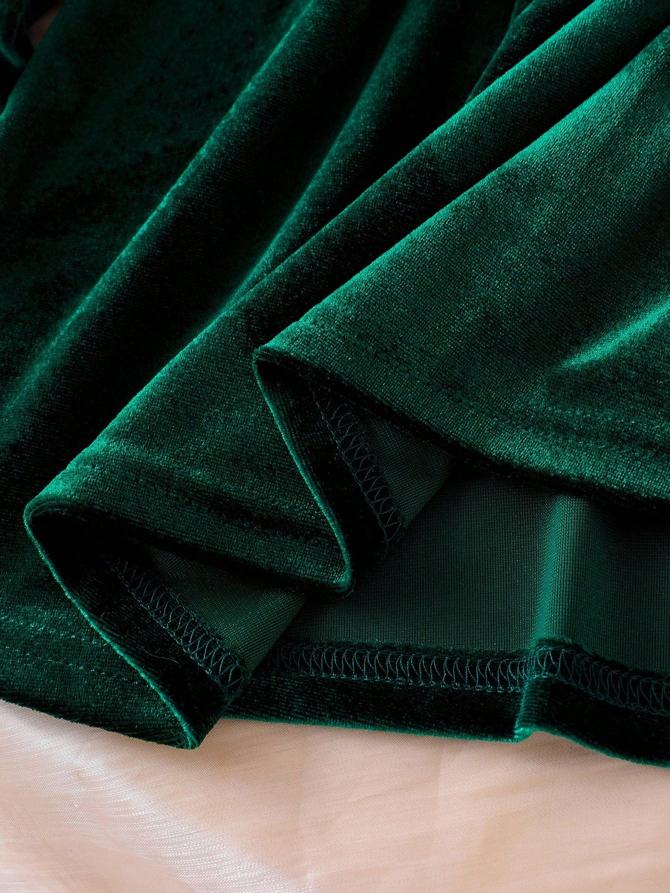 Prenda verde vestido de terciopelo para bebe con detalle del acabado interior