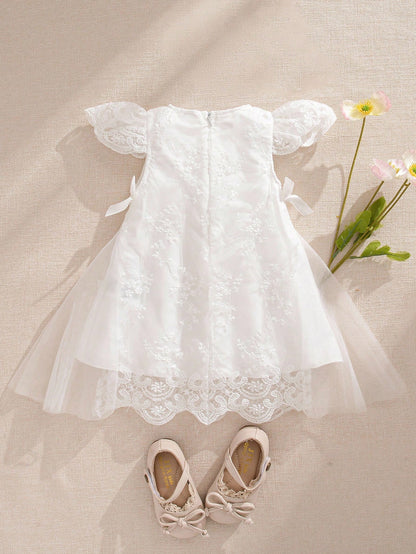 Prenda blanca vestido de tul bordado para bebe vista trasera con lazos
