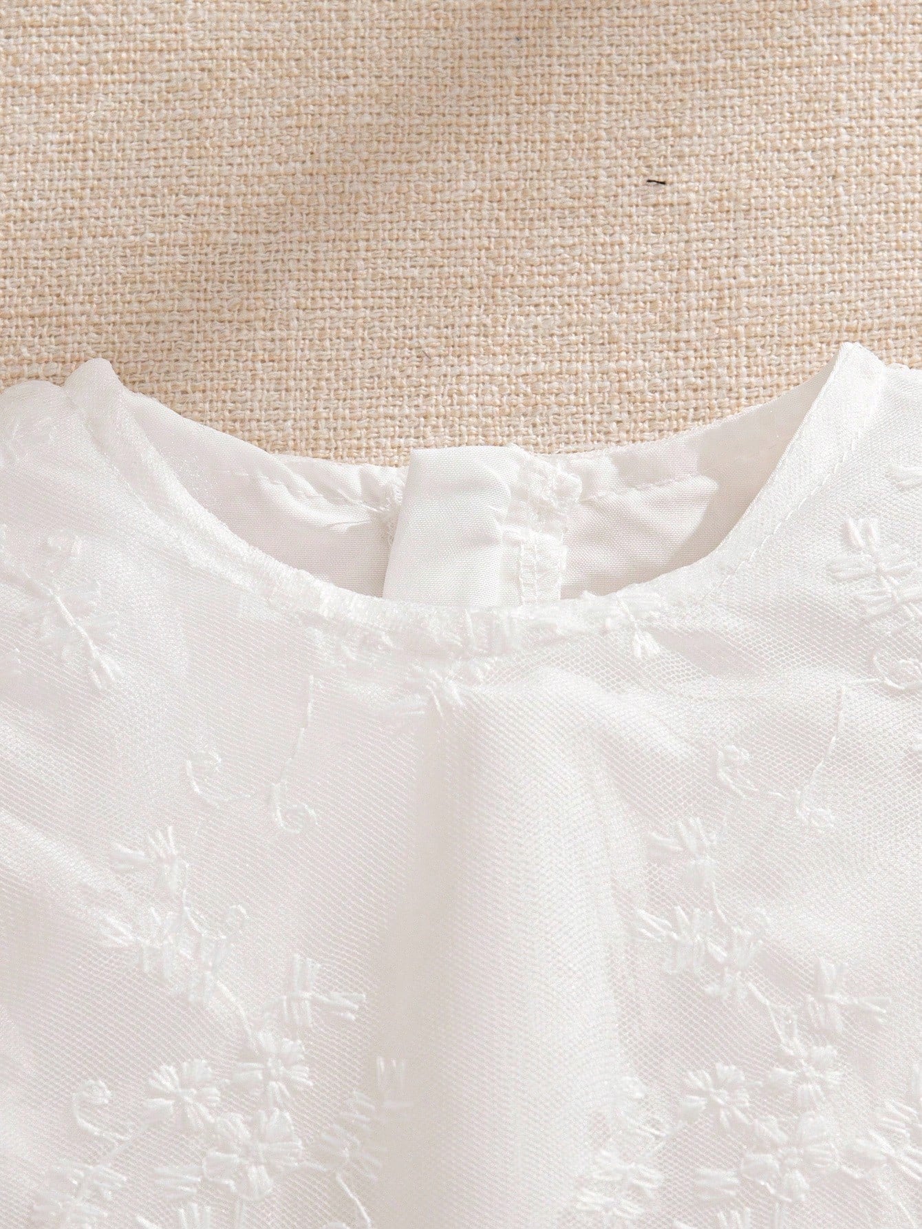 Prenda blanca vestido de tul bordado para bebe detalle de mangas con volantes
