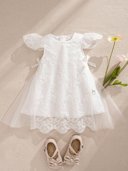 Prenda blanca vestido de tul bordado para bebe vista frontal con encaje
