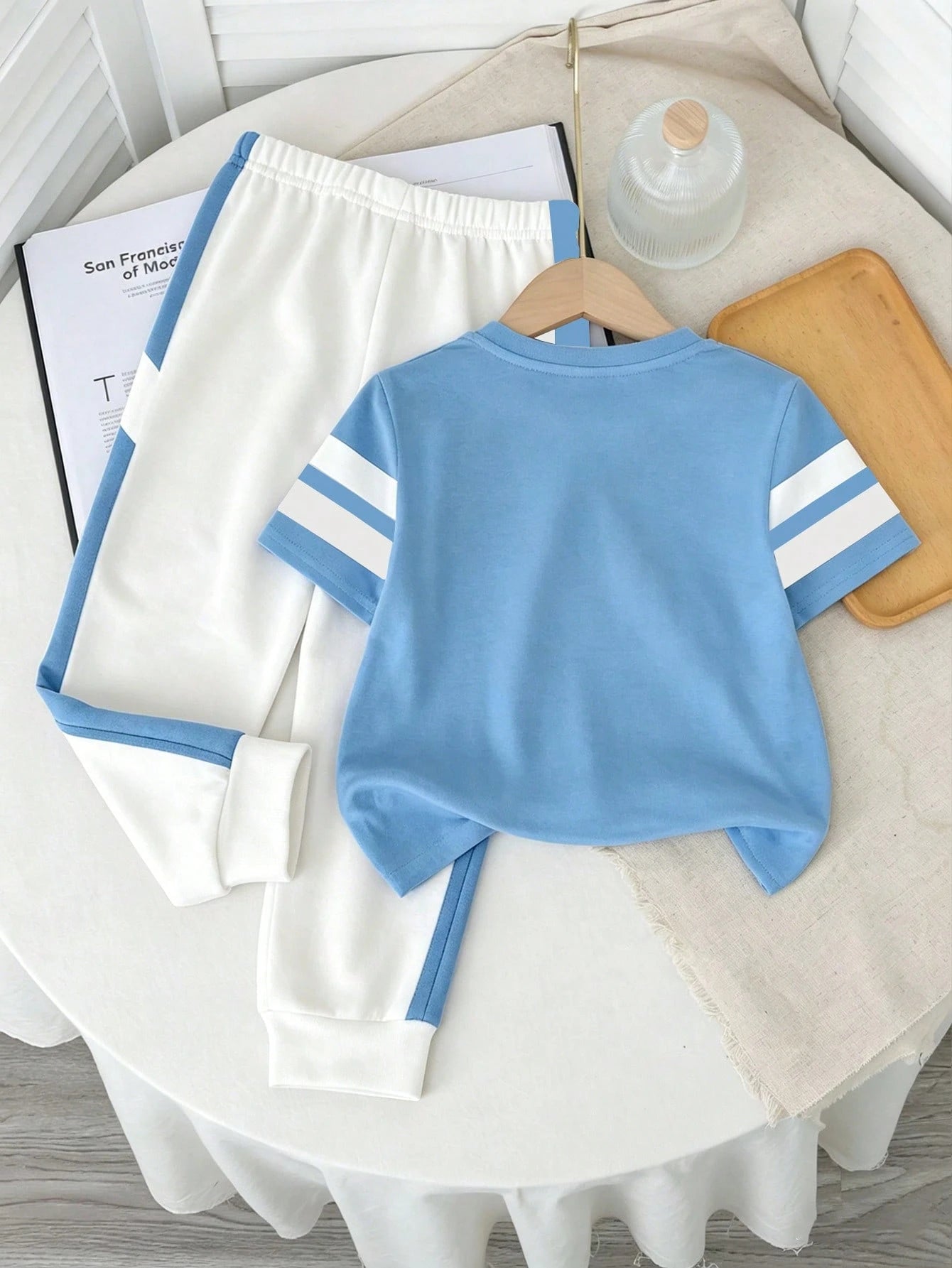 Prenda celeste conjunto deportivo para bebe con pantalón blanco vista trasera