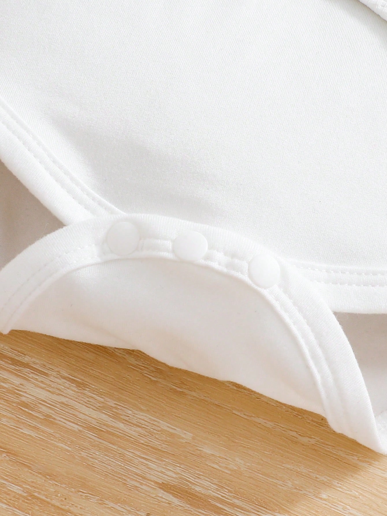Prenda blanca conjunto para bebe detalle de broches inferiores