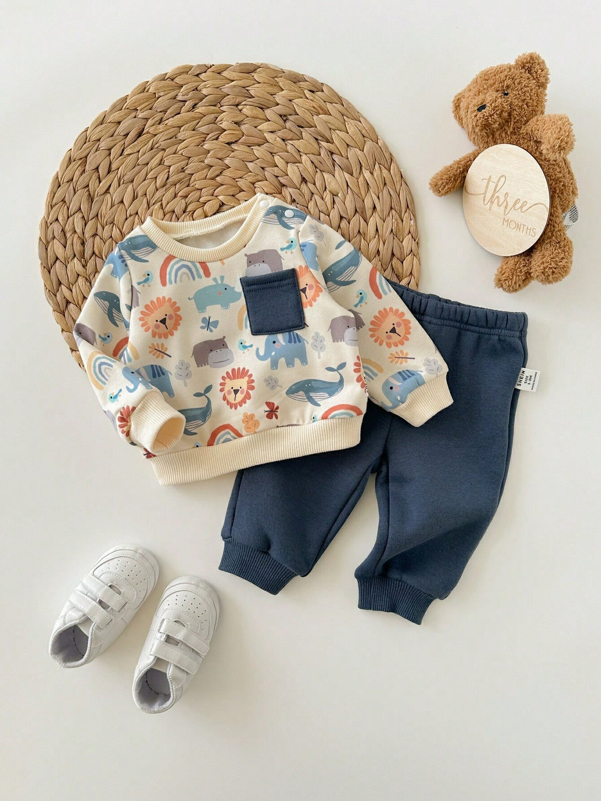 Prenda crema conjunto para bebe con estampado de animales y pantalón azul vista frontal