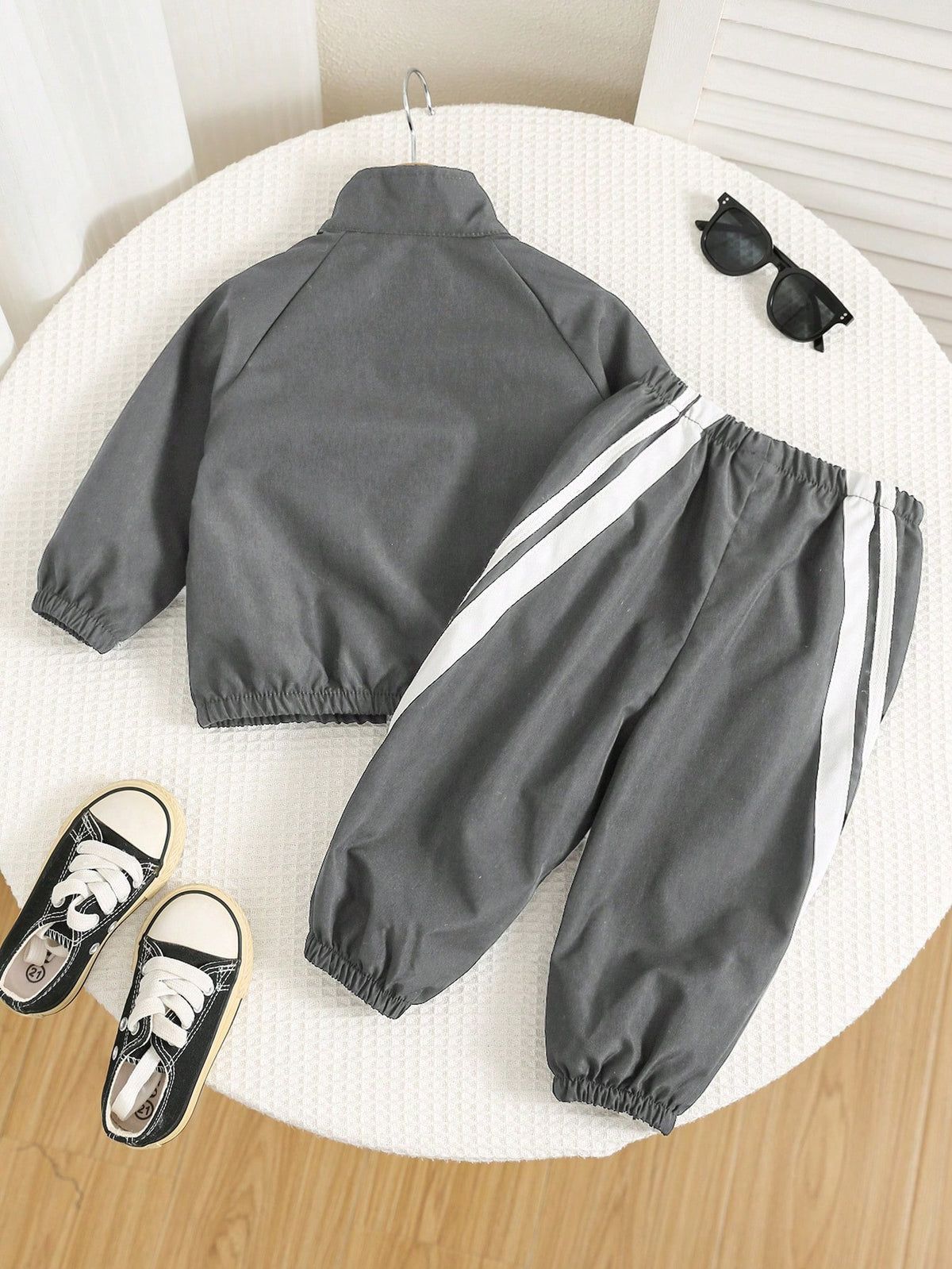 Prenda gris conjunto deportivo para bebe con franjas blancas vista trasera