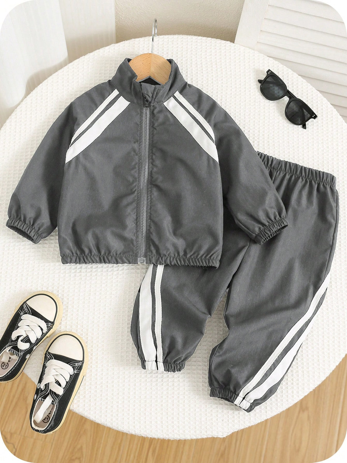 Prenda gris conjunto deportivo para bebe con franjas blancas vista frontal