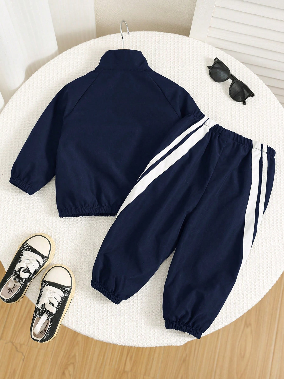 Prenda azul conjunto deportivo para bebe con franjas blancas vista trasera