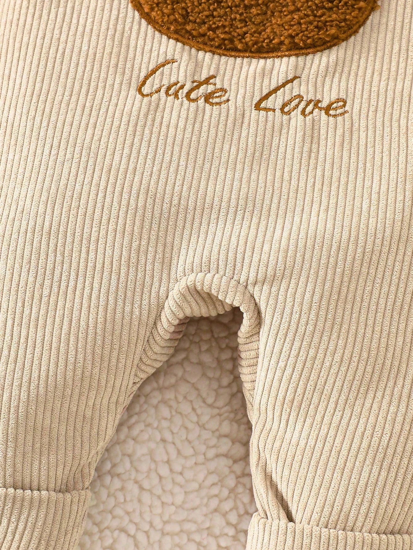 Prenda beige peto para bebe con detalle de bordado de oso en relieve