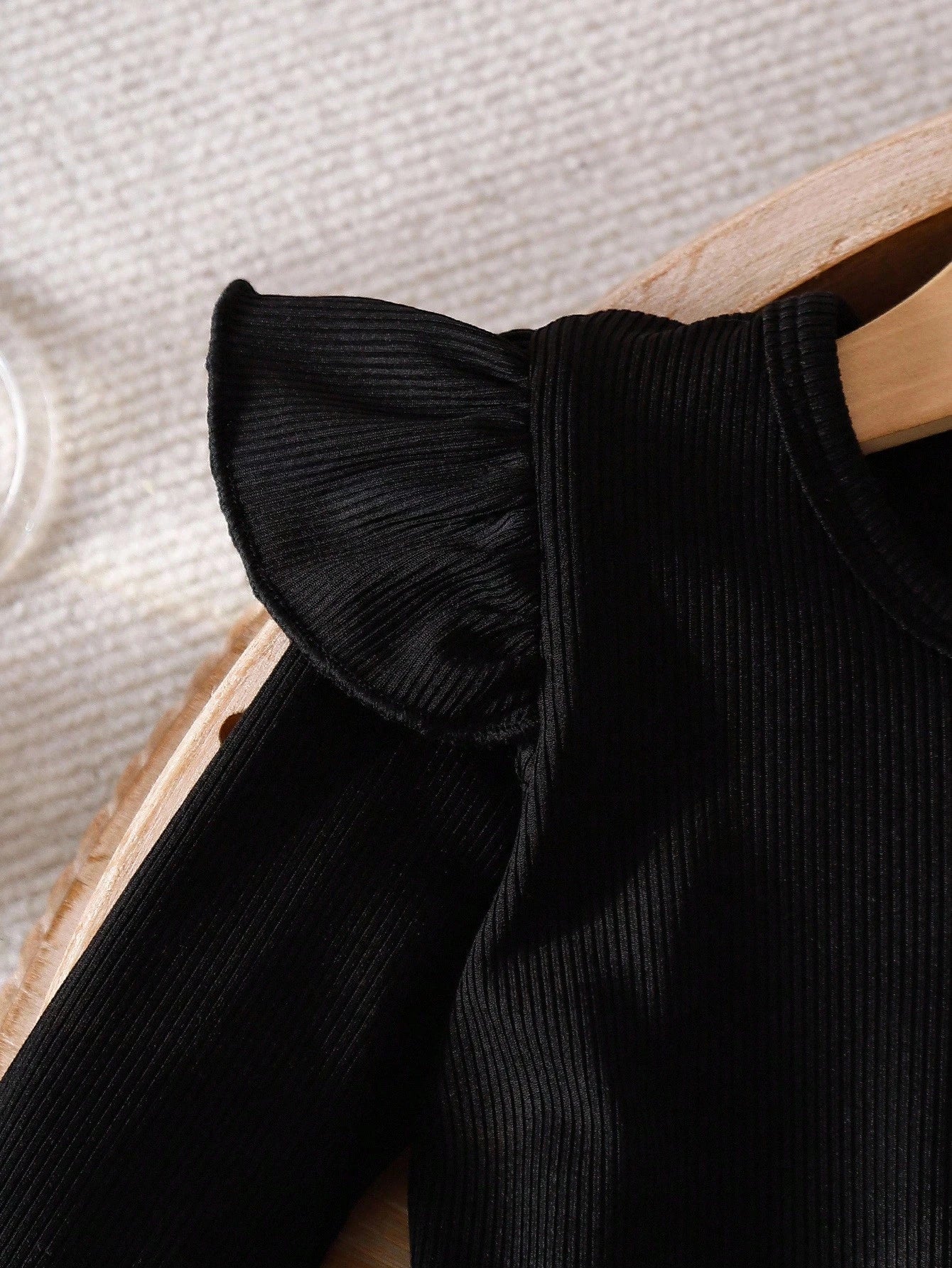 Prenda negra conjunto para bebe con detalle de volantes en los hombros