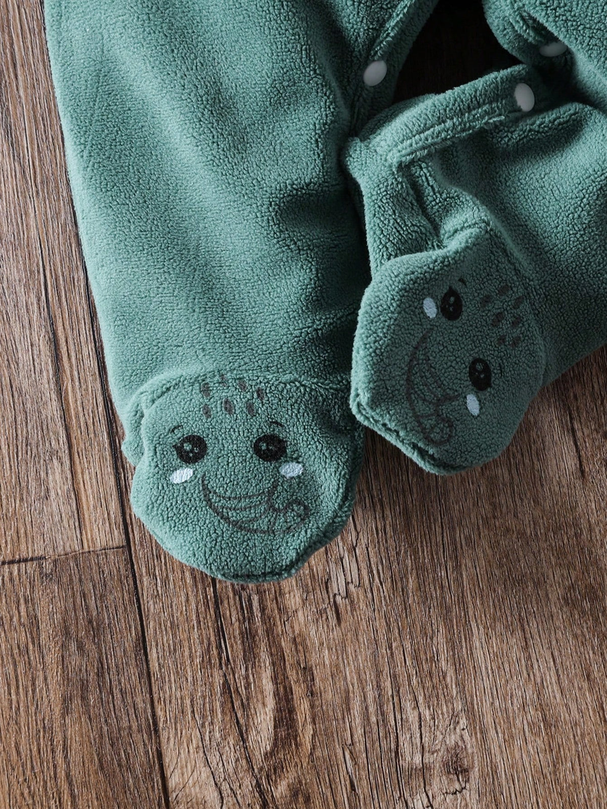 Prenda verde mameluco para bebe con detalle de pies cubiertos