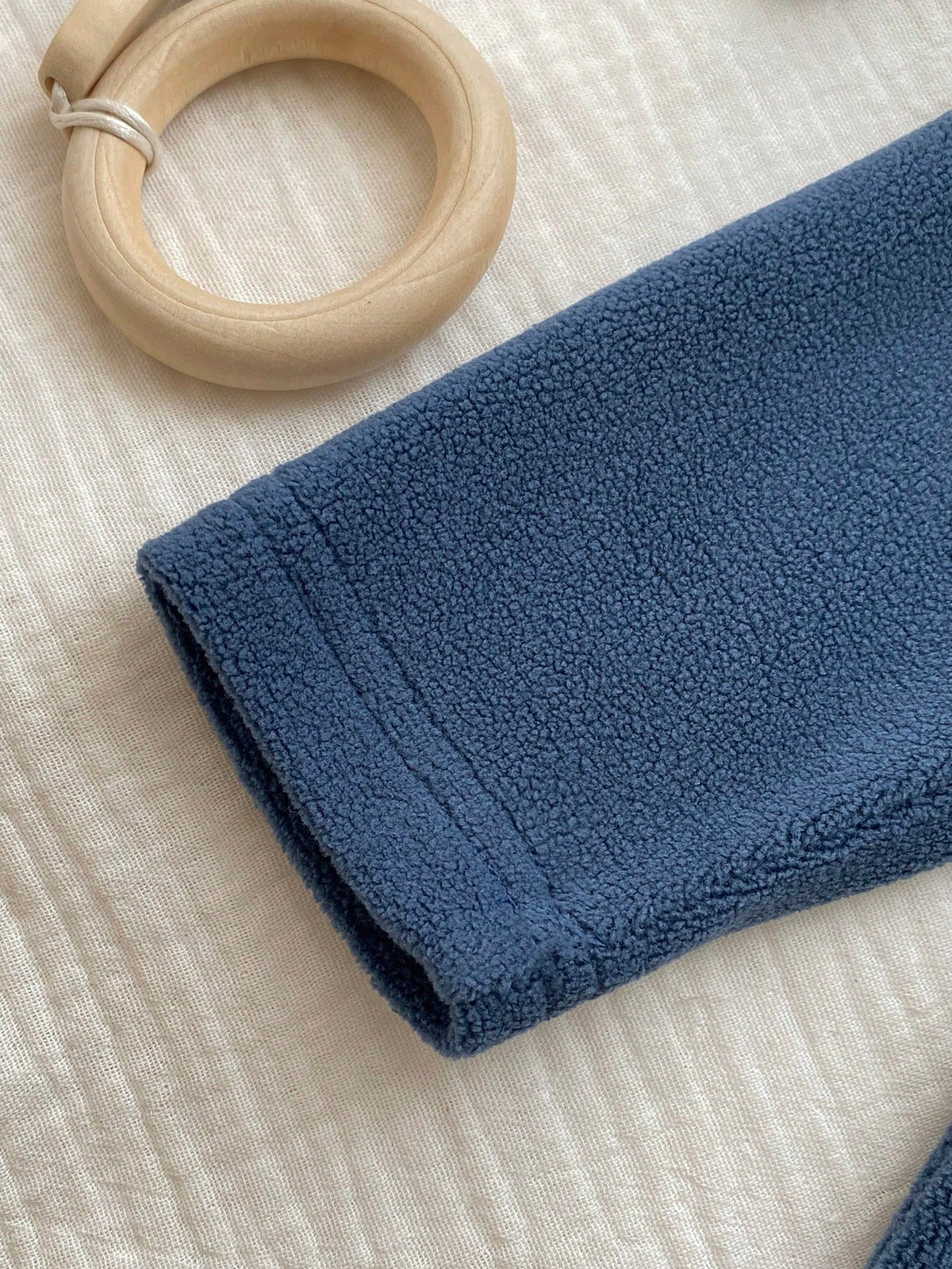 Prenda azul mameluco para bebe con detalle de pies cubiertos