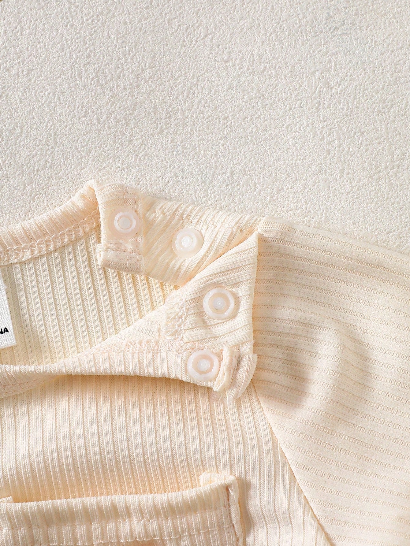 Prenda crema conjunto para bebe con detalle de botones a presión en el hombro