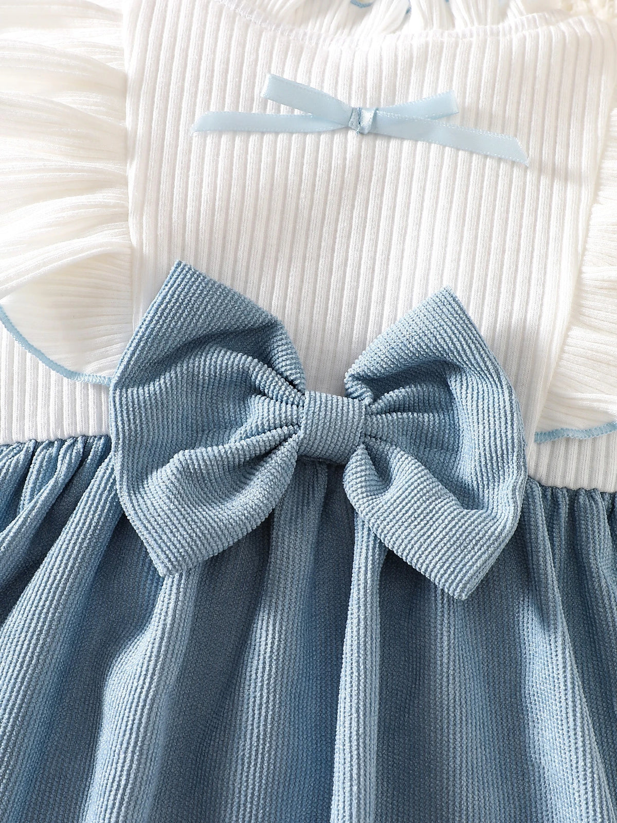Prenda azul y blanca vestido para bebe con detalle de lazo frontal
