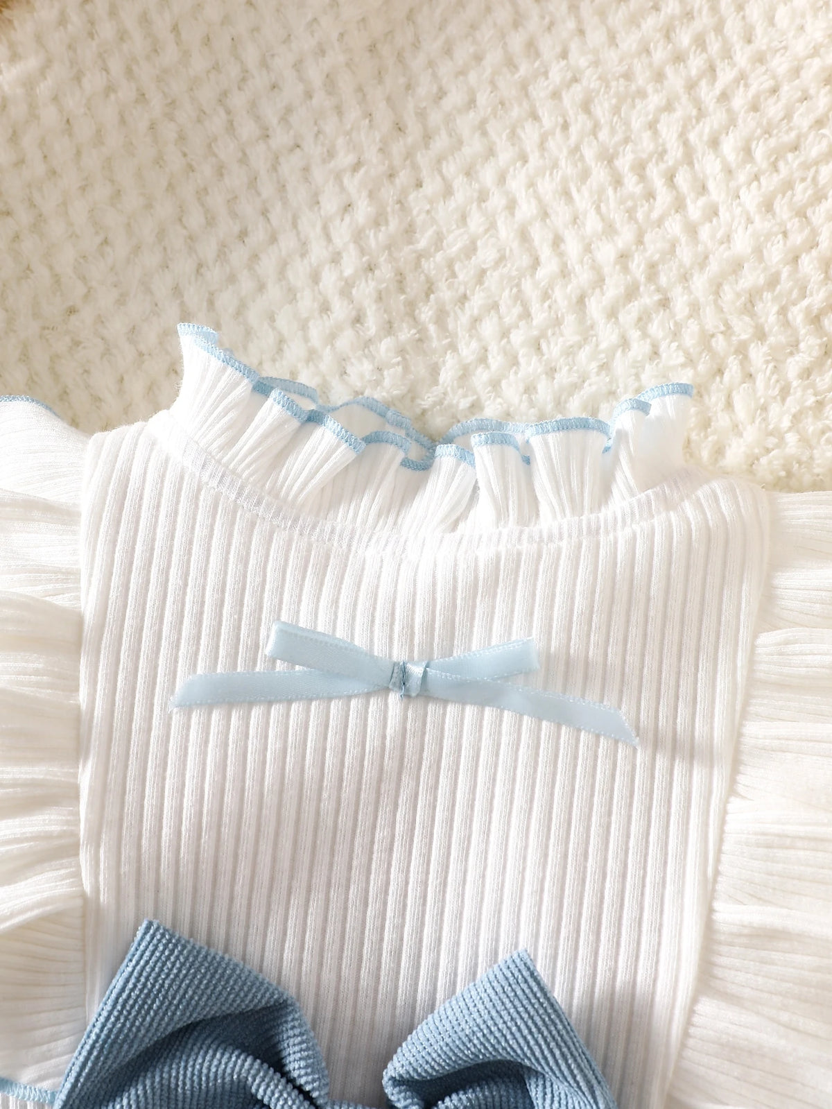 Prenda azul y blanca vestido para bebe con detalle de cuello y volantes
