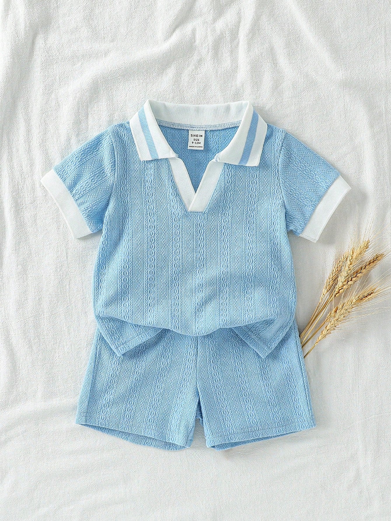 Prenda azul conjunto para bebe con cuello en contraste vista frontal

