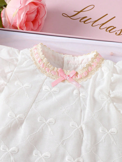 Prenda blanca vestido para bebe con detalle de cuello bordado y lazo rosa