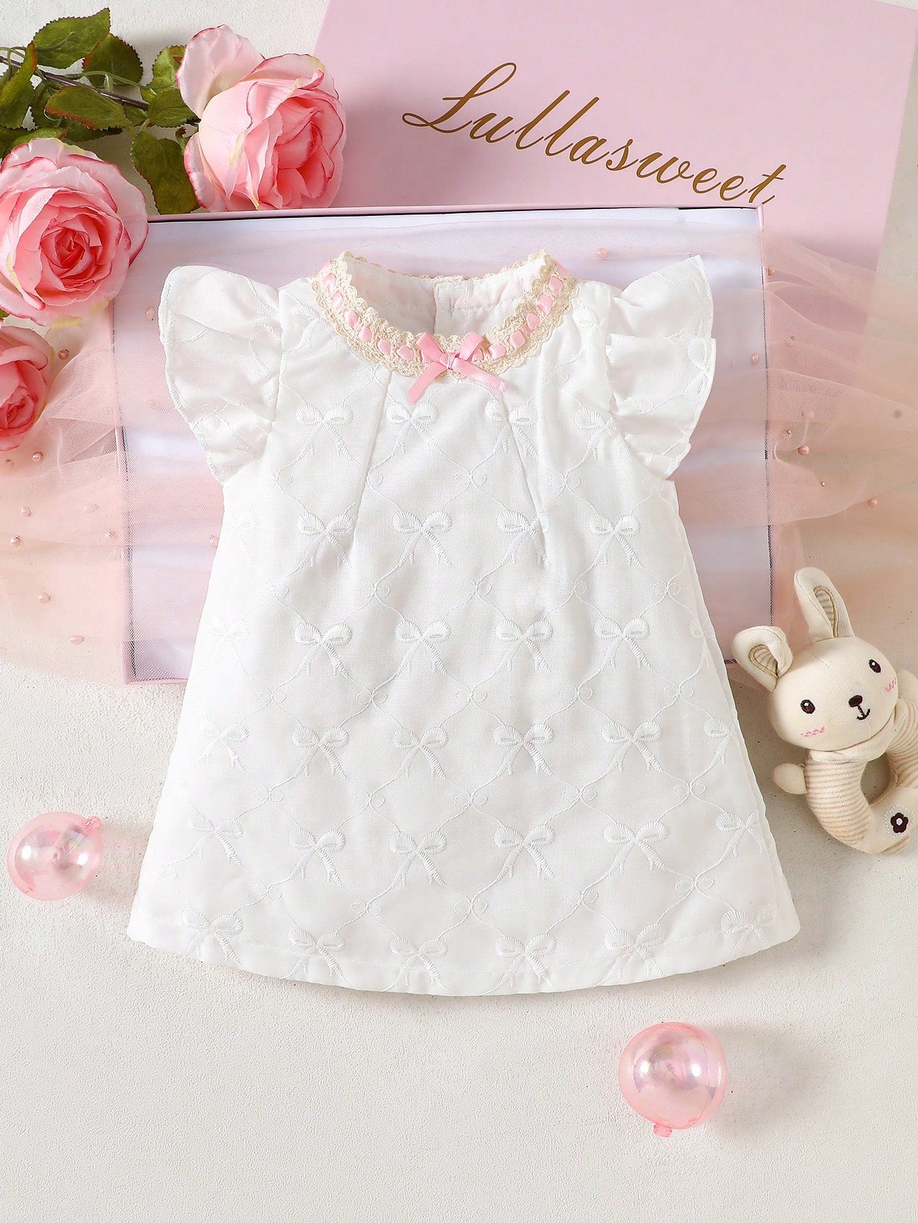 Prenda blanca vestido para bebe con encaje rosa y lazo vista frontal