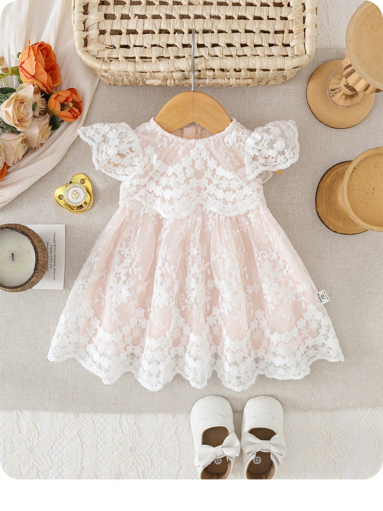 Prenda rosa claro vestido para bebe con encaje floral bordado vista frontal