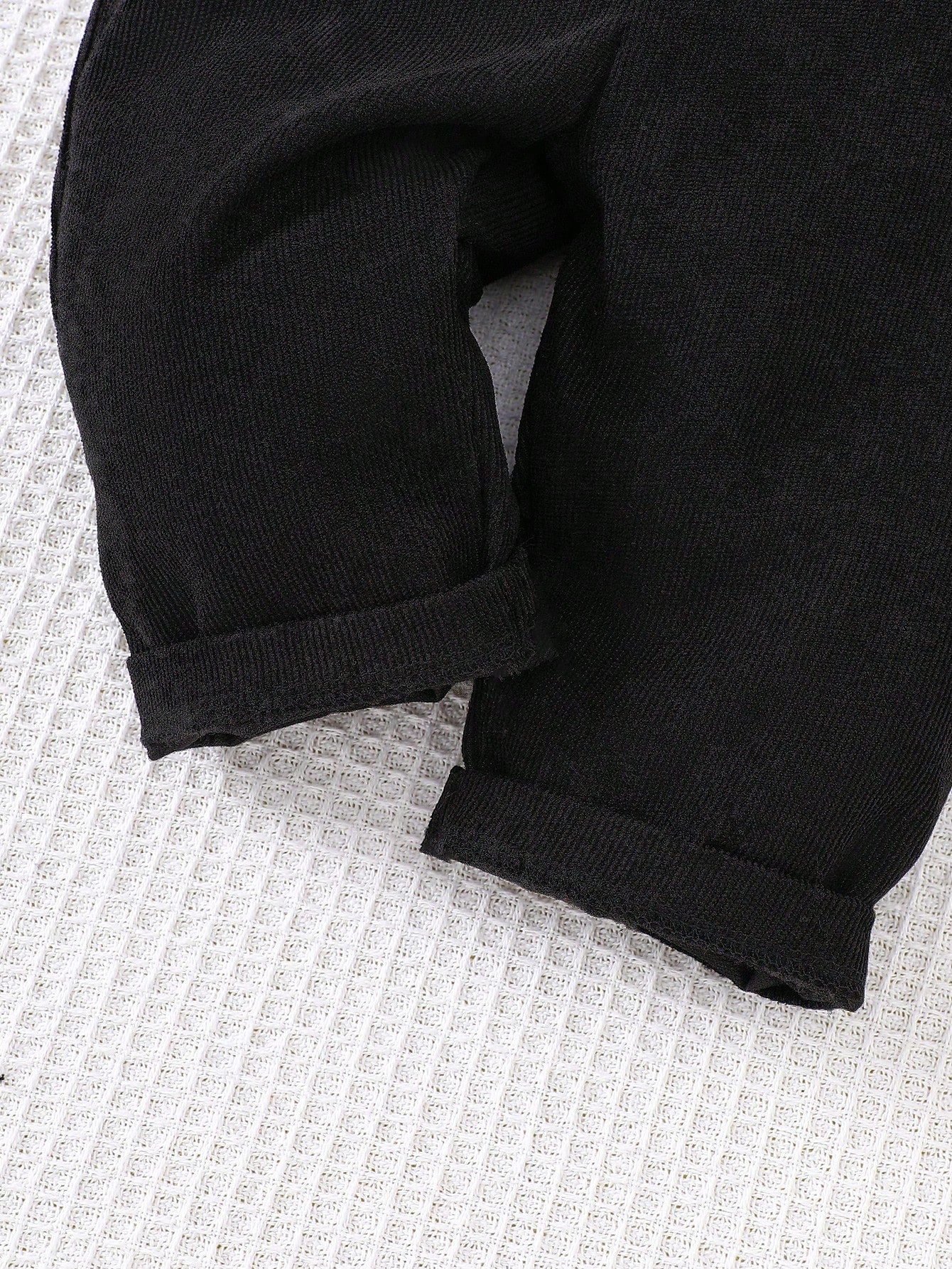 Prenda negro overol de pana para bebe detalle de tela y acabado