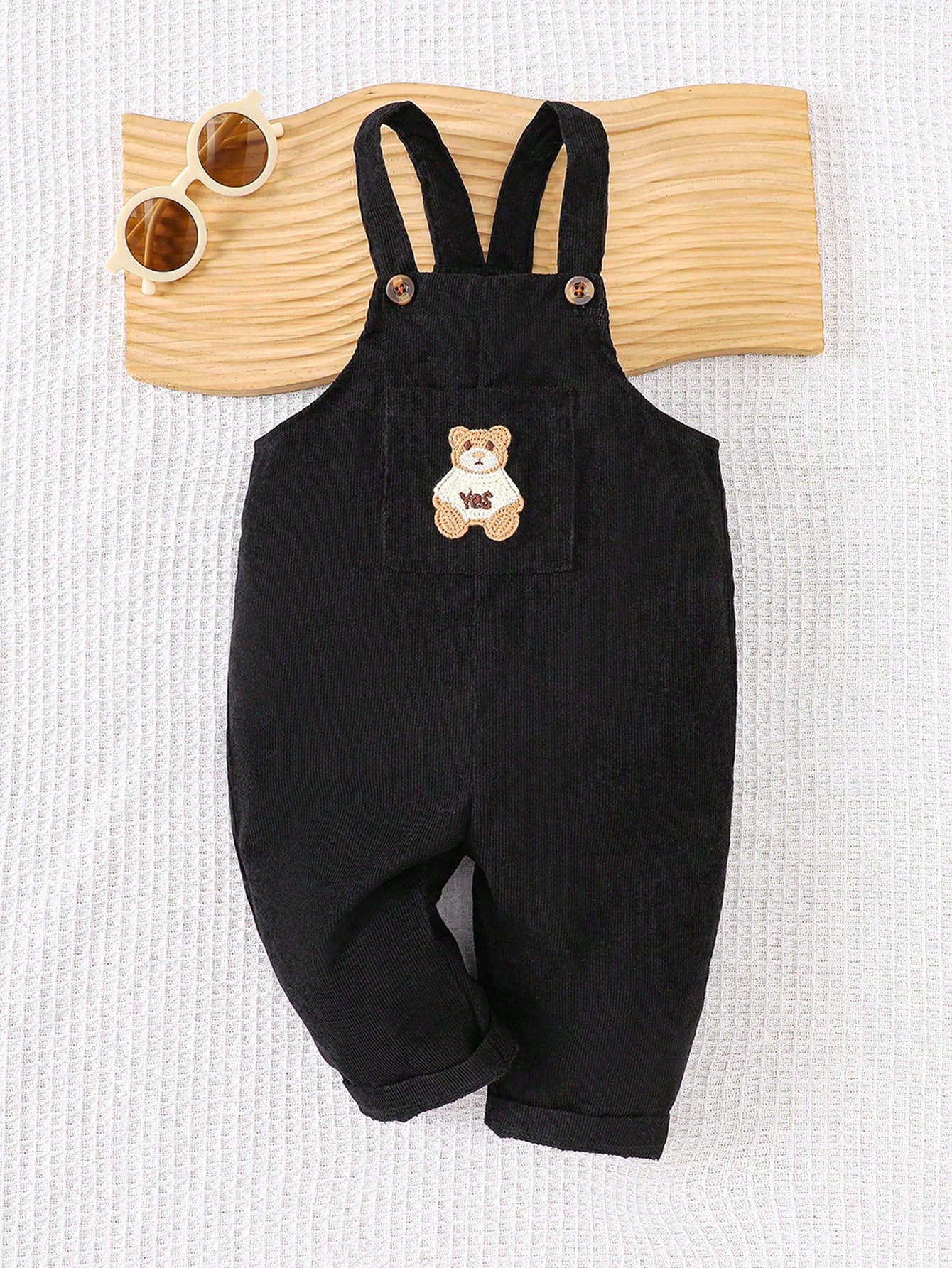 Prenda negro overol de pana para bebe con parche de oso vista frontal
