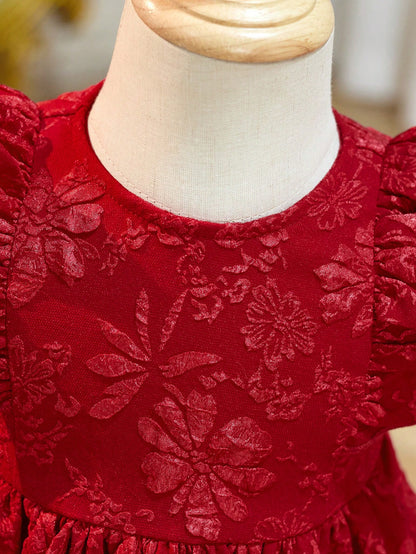 Prenda roja vestido para bebe detalle de textura floral en tela
