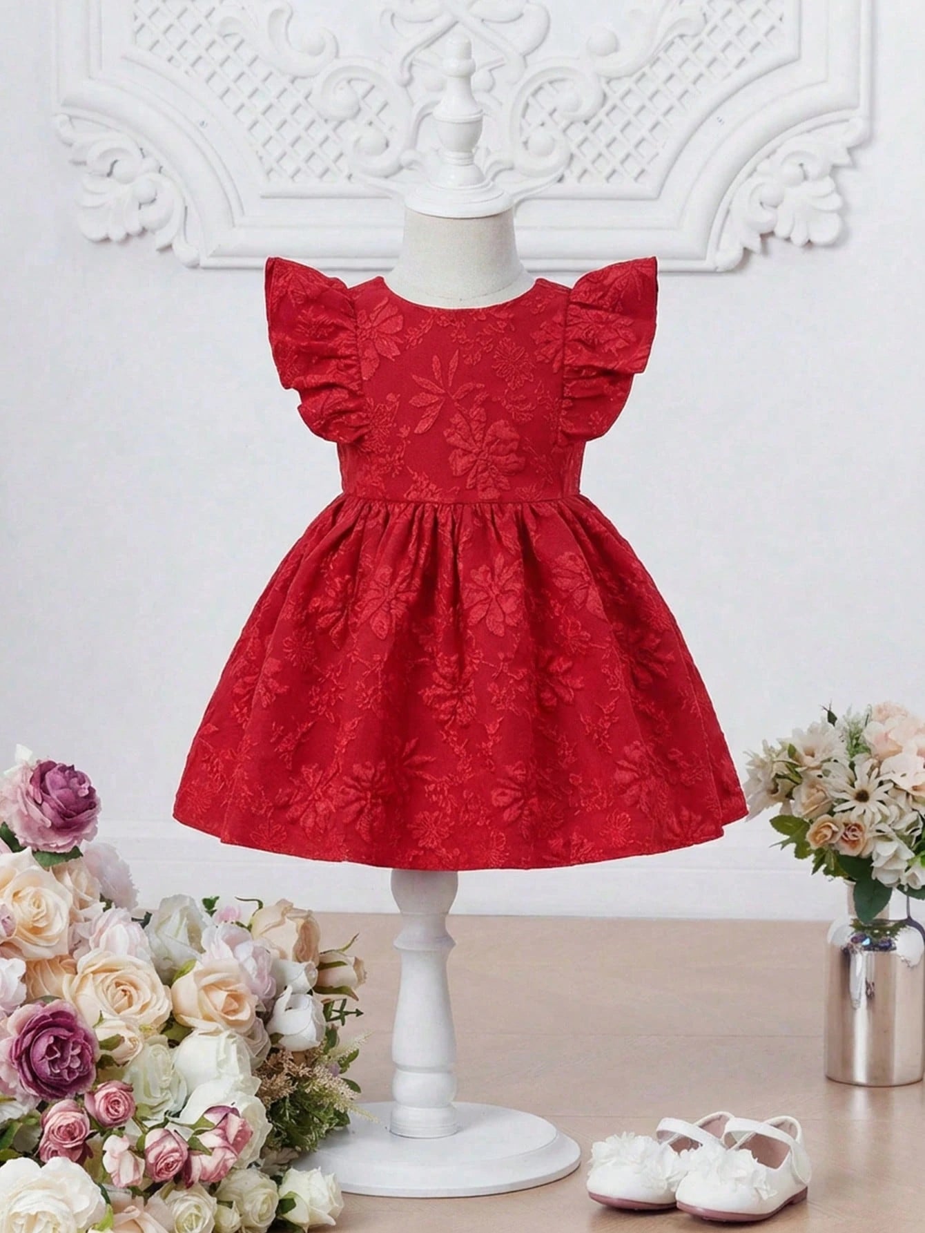Prenda roja vestido para bebe con relieve floral vista frontal
