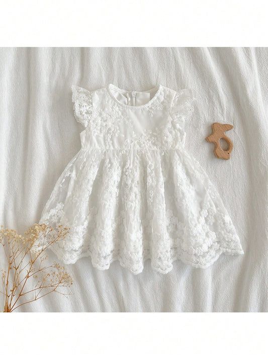 Prenda blanca vestido para bebe con bordado floral vista frontal
