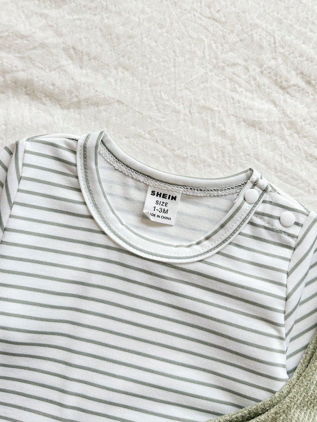 Prenda blanca conjunto para bebe con blusa rayada de manga larga detalle del cuello