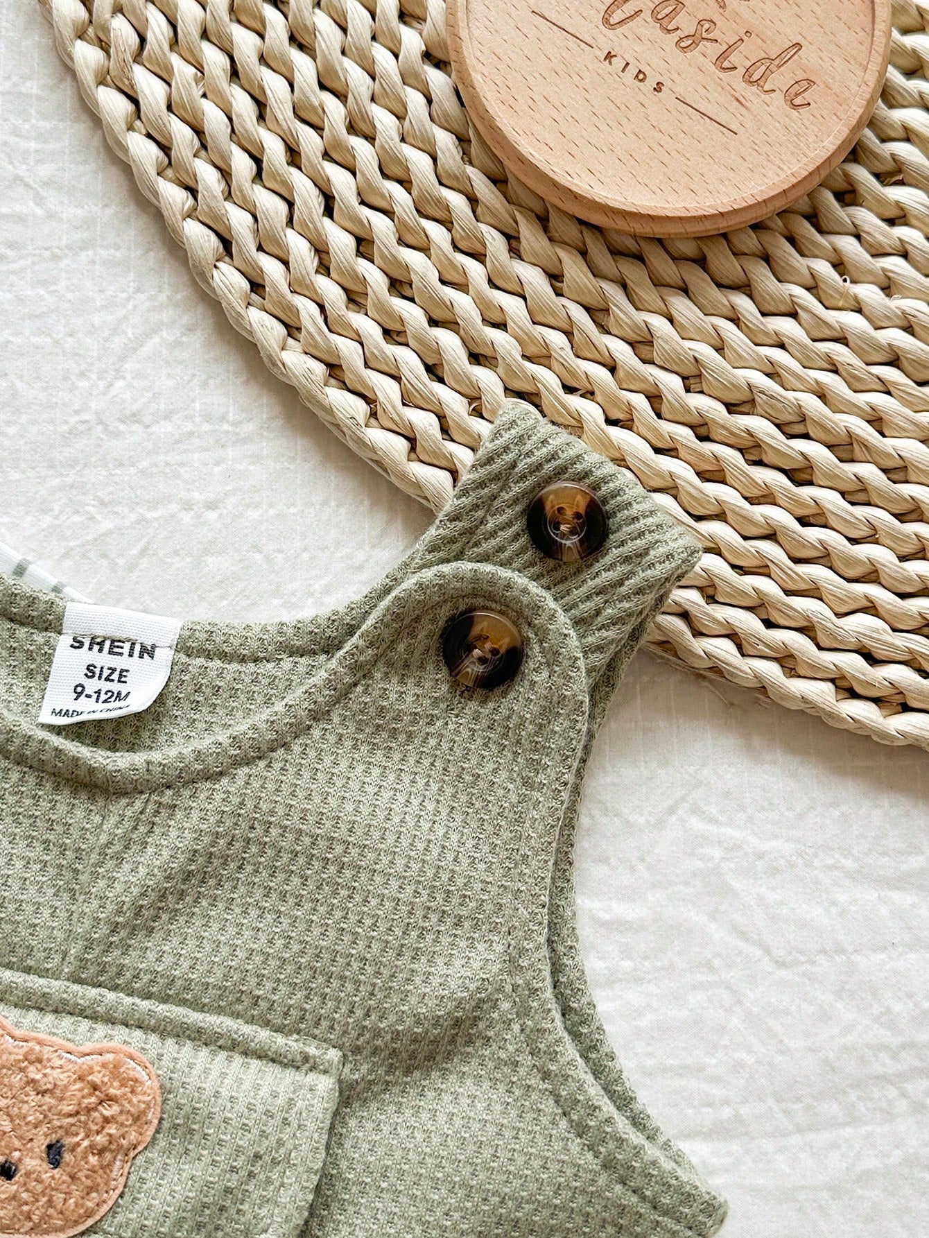 Prenda verde conjunto para bebe con peto texturizado y botones en tirantes detalle lateral