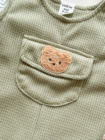 Prenda verde conjunto para bebe con bolsillo frontal y parche de oso detalle cercano