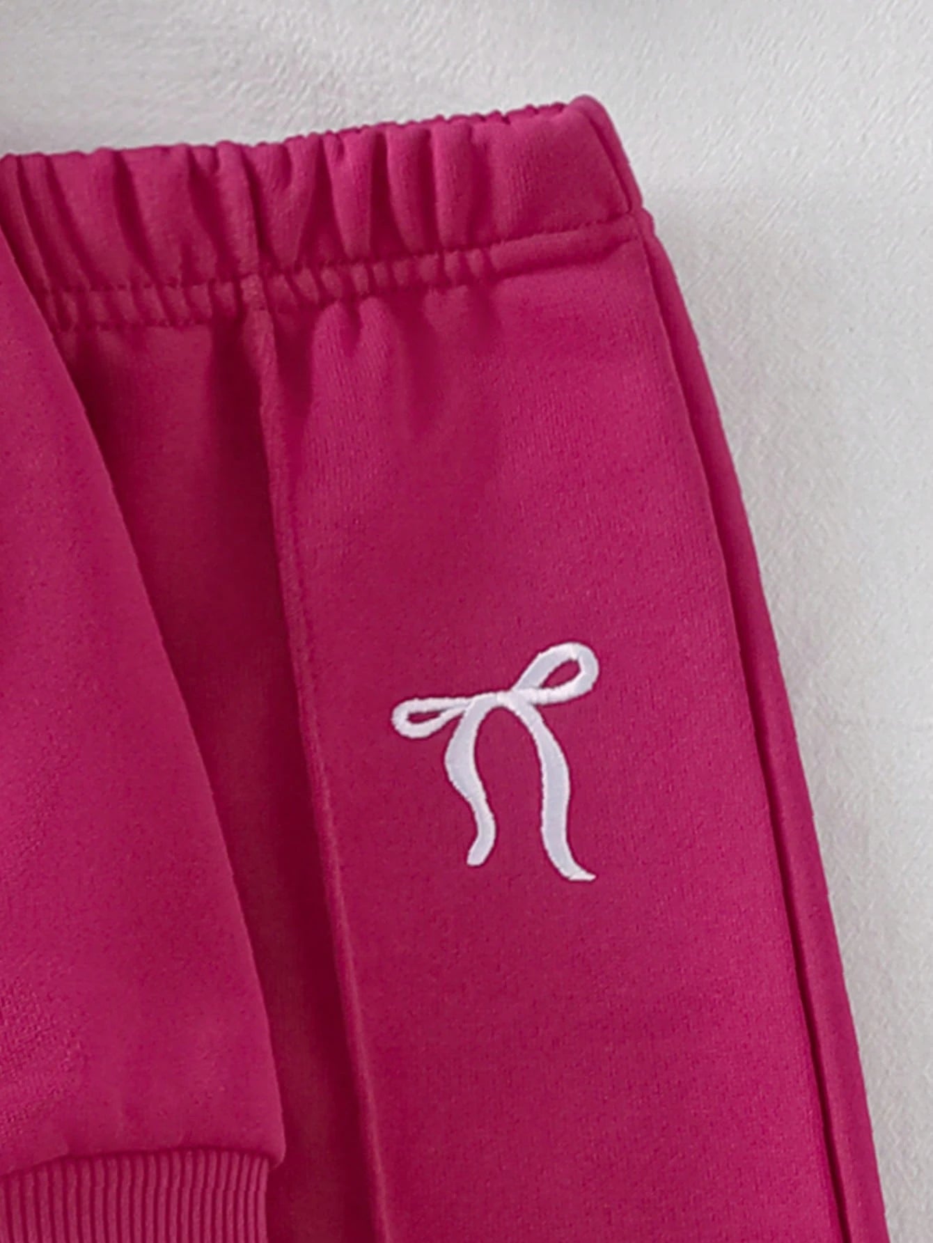 Prenda fucsia conjunto para bebe detalle de pantalón con lazo bordado