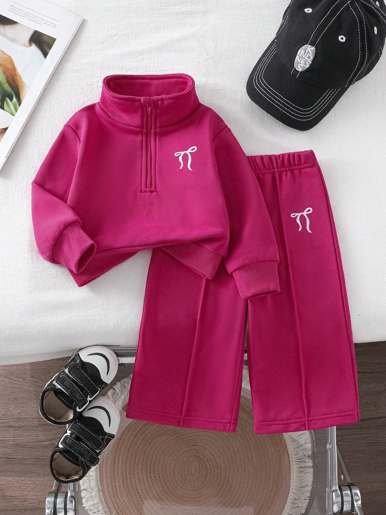 Prenda fucsia conjunto de dos piezas para bebe vista frontal con lazos bordados